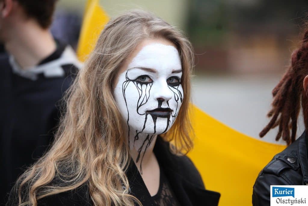 Uczennica z makijażem teatralnym podczas wydarzenia plastycznego pod ratuszem.