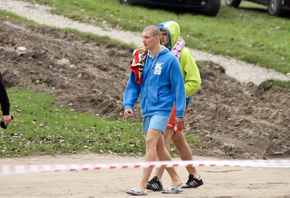 Morsy w stroju sportowym idą na zbiórkę podczas inauguracji sezonu zimowych kąpieli w Olsztynie.