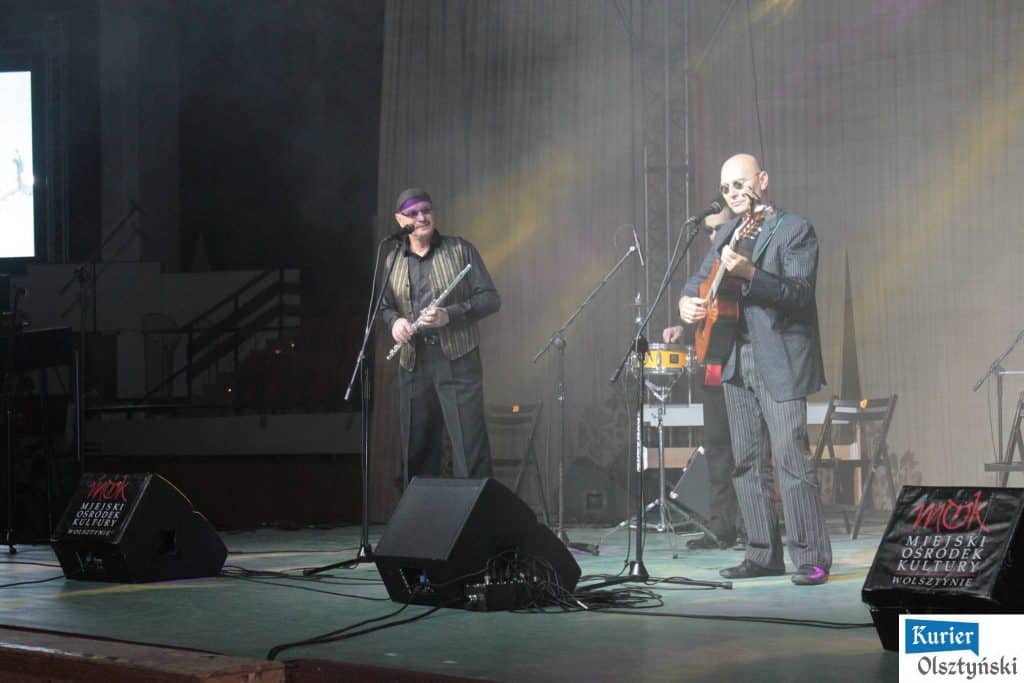 Muzycy na scenie podczas koncertu w ramach Dnia Papieskiego, śpiewają i grają na instrumentach, w tle ekran LED.