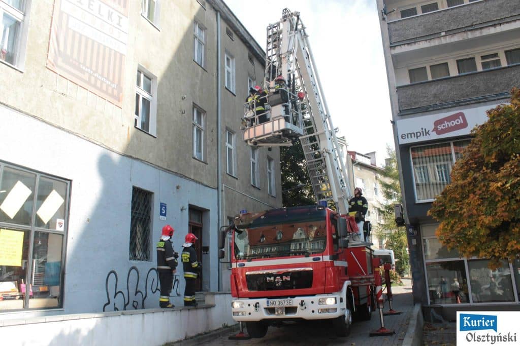 Strażacy na podnośniku przy budynku, interweniują podczas akcji ratunkowej na ulicy Liszewskiego.