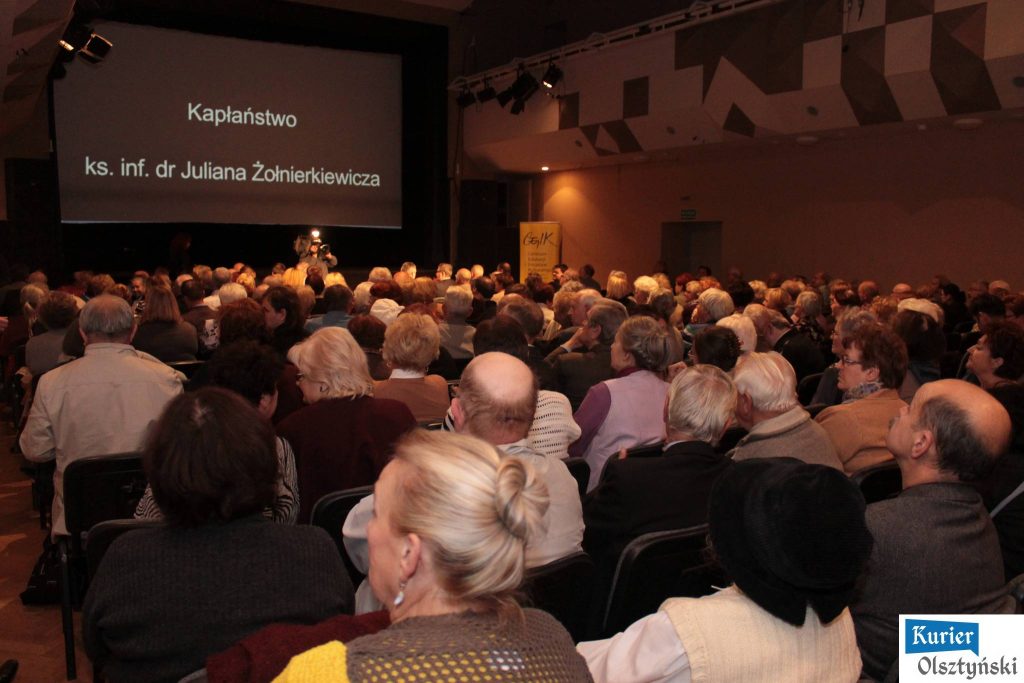 Sala z dużą liczba widzów podczas projekcji filmu o Julianie Żołnierkiewiczu, na ekranie napis o kapłaństwie.