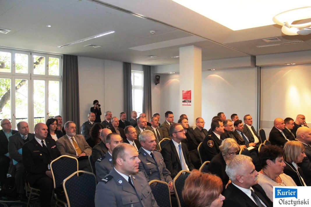 Uczestnicy konferencji słuchają prezentacji w dużej sali, wśród nich policjanci w mundurach i cywilni goście.