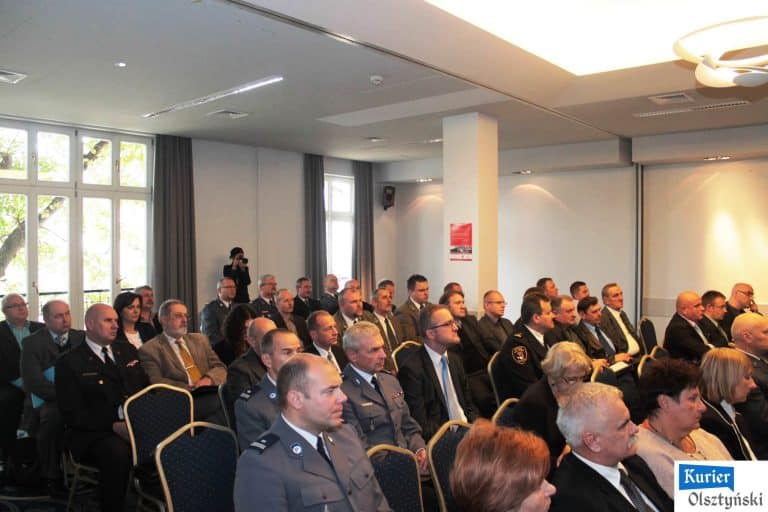 Uczestnicy konferencji słuchają prezentacji w dużej sali, wśród nich policjanci w mundurach i cywilni goście.