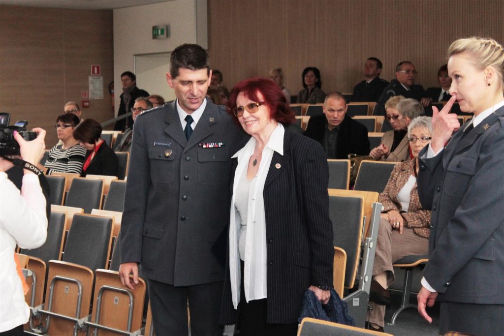 Uczestnicy gali filmowej o tematyce więziennej w sali konferencyjnej urzędu, rozmawiają i pozują do zdjęcia.