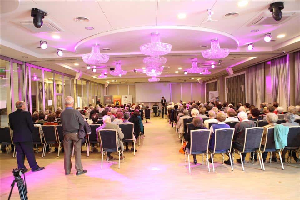 Sala konferencyjna wypełniona seniorami podczas inauguracyjnego wydarzenia Akademii Trzeciego Wieku w Olsztynie.