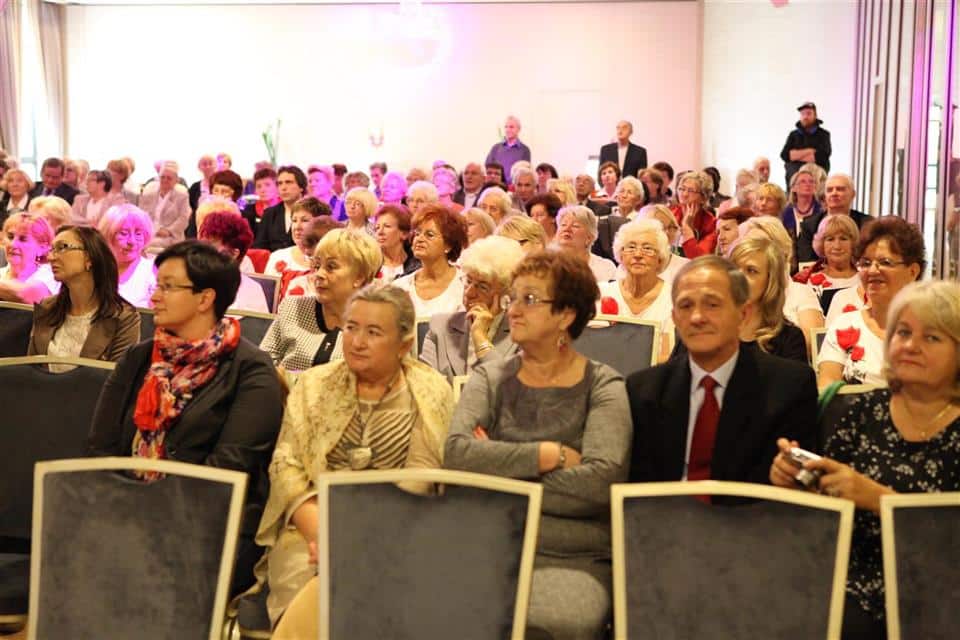 Uczestnicy uroczystości jubileuszu Akademii Trzeciego Wieku siedzą na sali konferencyjnej, słuchają wykładu.