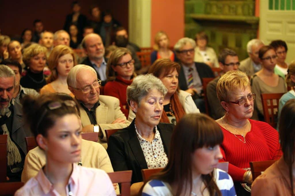 Grupa ludzi na sali, udział w kulturze podczas dyskusji kulturalnego talk show.