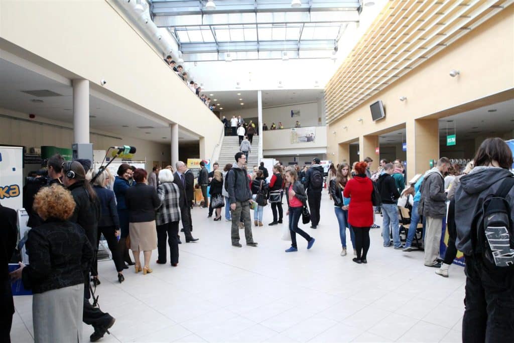 Liczni odwiedzający na targach pracy w centrum konferencyjnym Uniwersytetu Warmińsko-Mazurskiego, rozmowy i kolejki do stoisk.