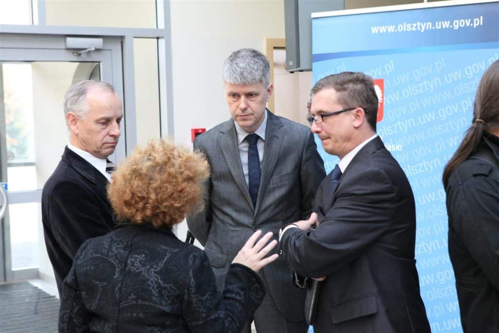 Grupa ludzi rozmawia podczas targów pracy w centrum konferencyjnym na Uniwersytecie Warmińsko-Mazurskim.
