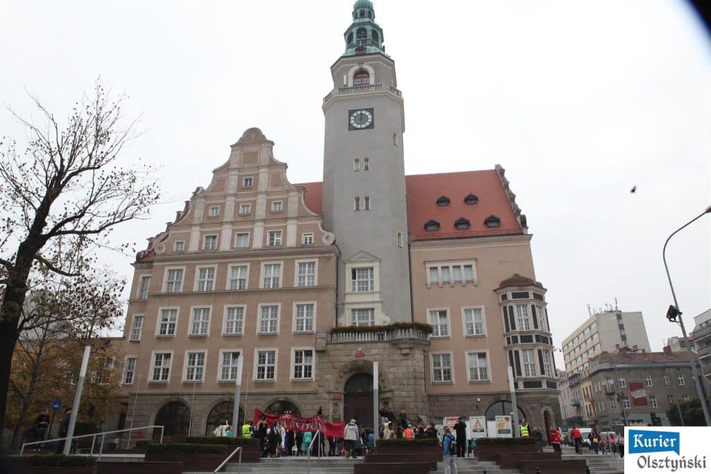 Młodzi artyści z zakrytymi płótnem placem przed ratuszem w Olsztynie podczas obchodów 25-lecia szkoły.