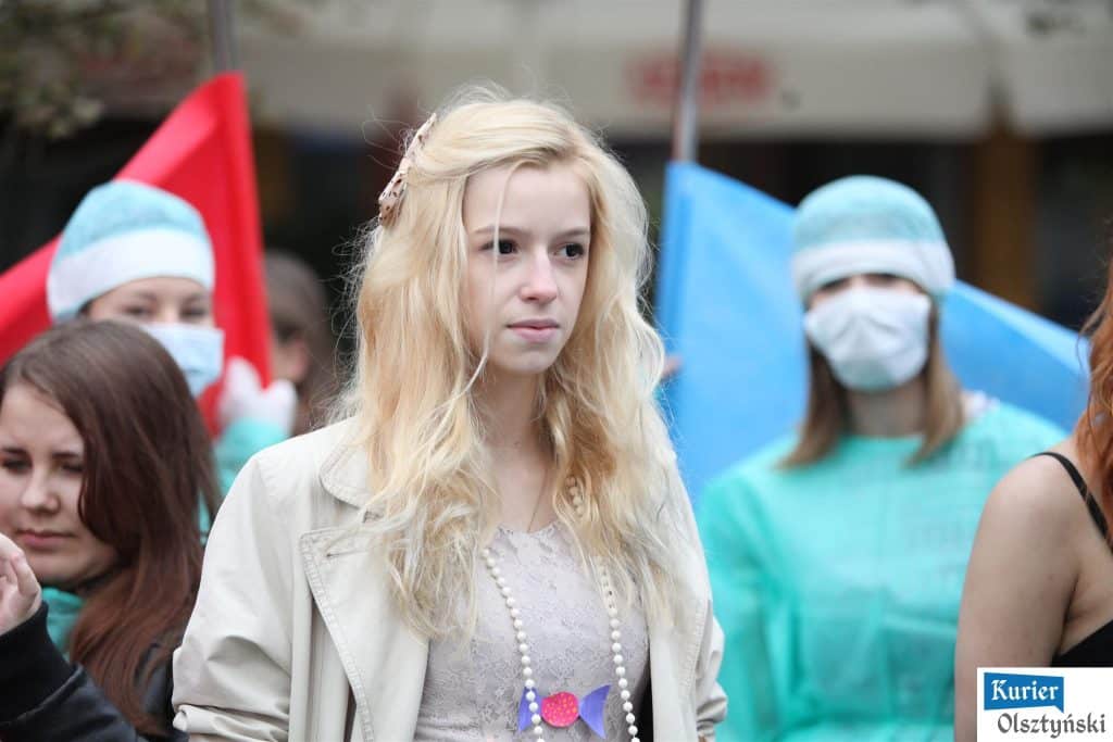 Uczennica w centrum tłumu podczas obchodów 25-lecia szkoły plastycznej w Olsztynie.