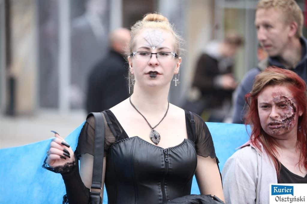 Uczennice w kostiumach z motywami gotyckimi i makijażem w stylu horror, na ulicy podczas obchodów 25-lecia szkoły artystycznej.