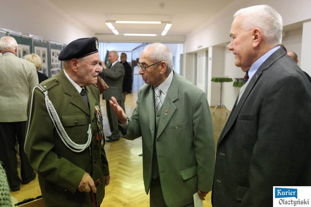 Uczestnicy rozmawiają podczas otwarcia wystawy zdjęć w urzędzie wojewódzkim.