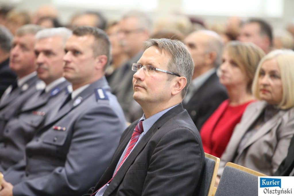 Uczestnicy uroczystości Dnia Edukacji Narodowej w urzędzie wojewódzkim, wielu stoi w rzędach, część w mundurach policyjnych.