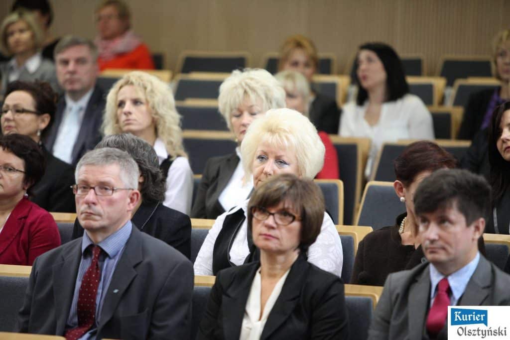 Uczestnicy wydarzenia Dnia Edukacji Narodowej w sali konferencyjnej, siedzący i słuchający prelekcji.