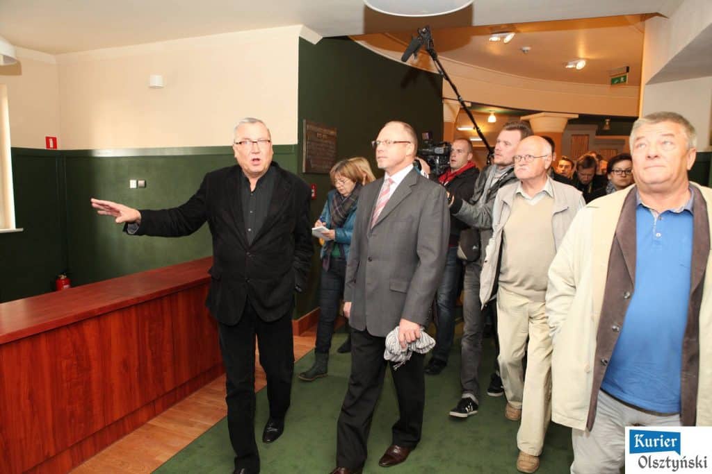 Grupa ludzi wchodząca do odremontowanego teatru podczas prezentacji nowoczesnych sal.