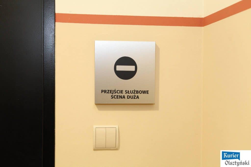 Tabliczka na drzwiach z napisem 'Przejście służbowe scena duża' oraz symbol oznaczający zakaz wstępu.