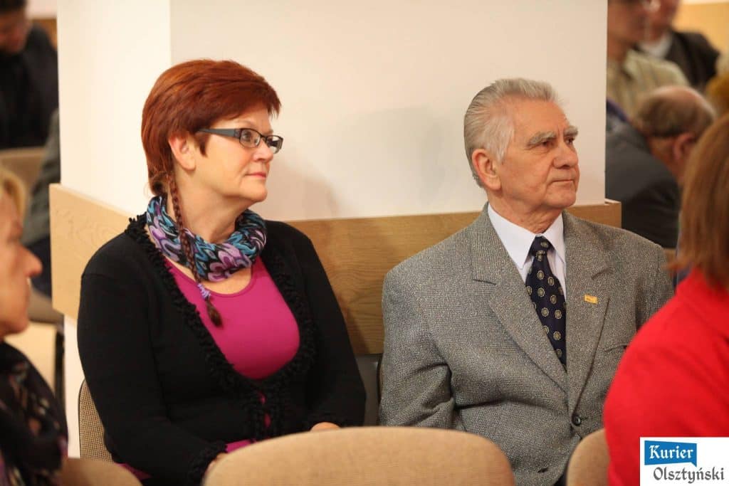 Widok na dwóch siedzących uczestników podczas gali konkursu satyrycznego, kobieta z czerwoną fryzurą i mężczyzna z siwymi włosami.