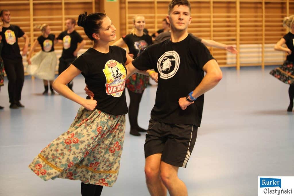 Tancerze i zainteresowani uczestnicy podczas otwartego treningu w sali fitness.