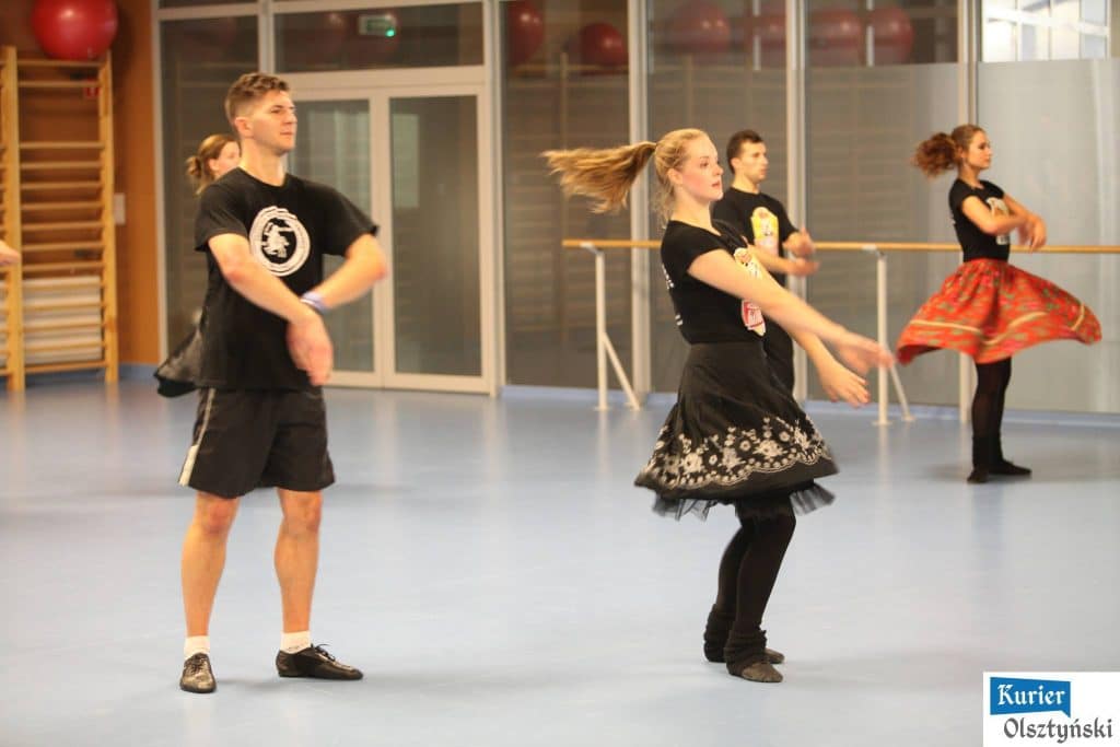 Tancerze podczas otwartego treningu zespołu folklorystycznego w sali fitness.