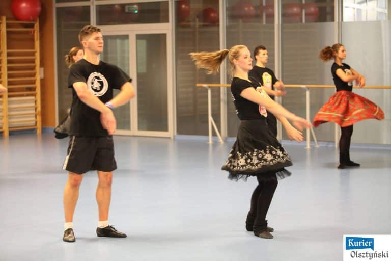 Tancerze podczas otwartego treningu zespołu folklorystycznego w sali fitness.