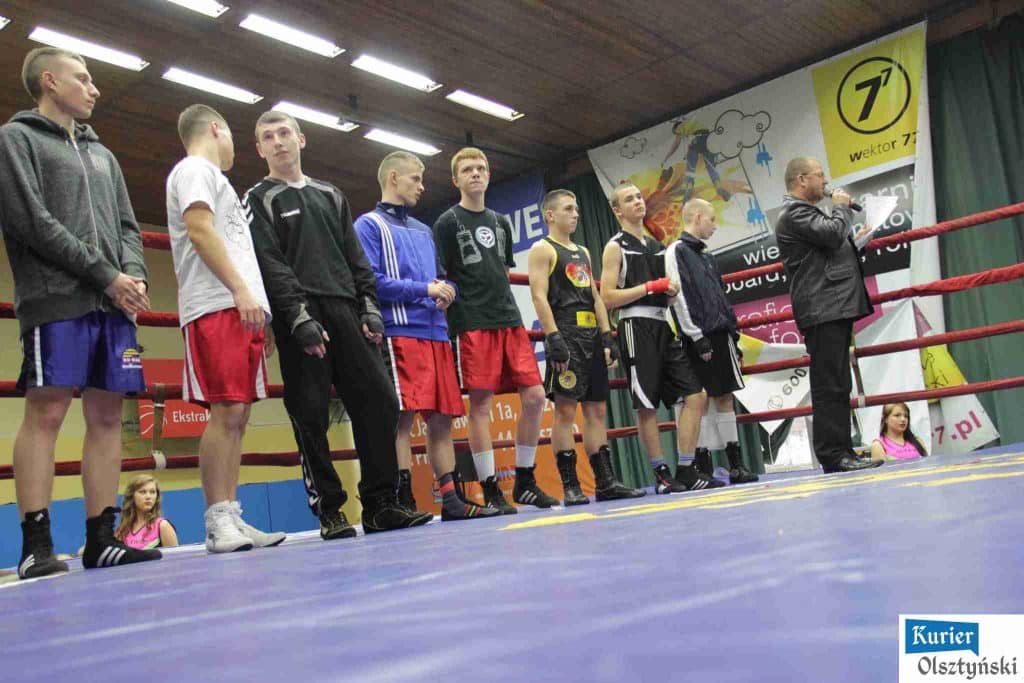 Zawodnicy w ringu podczas turnieju bokserskiego, prezentują się na linii startu przed walką.