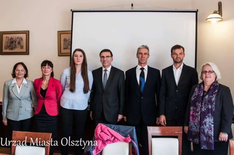 Grupa ludzi w sali konferencyjnej w ratuszu podczas spotkania z medalistką taekwondo.
