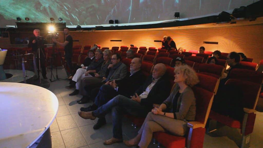 Widownia podczas festiwalu BlueBox w olsztyńskim planetarium, siedzący ludzie i scena.