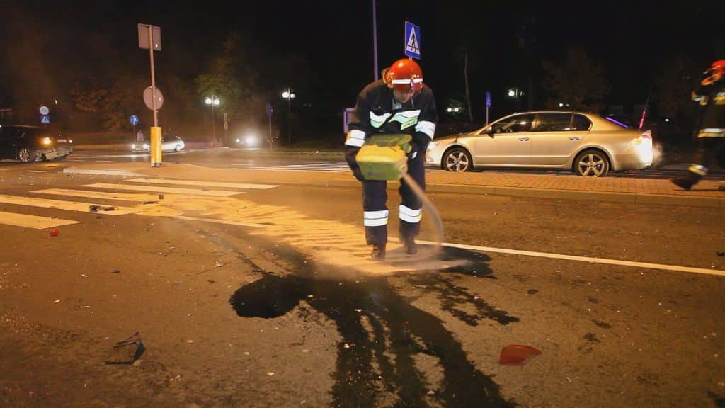 Ratownicy i policja zabezpieczają miejsce kolizji na ulicy Sielskiej w Olsztynie, w tle uszkodzone samochody.