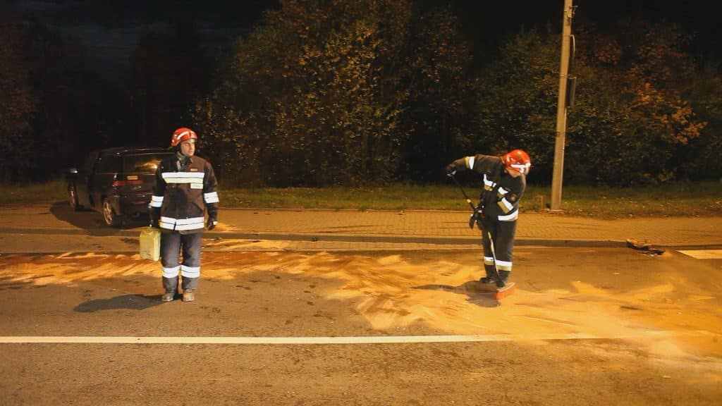 Strażacy na miejscu kolizji z uszkodzonymi pojazdami i zablokowaną drogą wieczorem na Sielskiej.