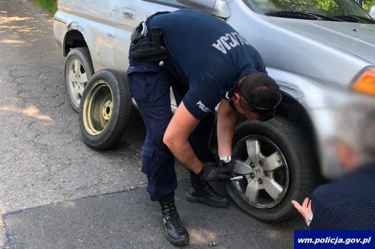 Policjanci pomogli starszemu małżeństwu przy wymianie uszkodzonego koła w aucie