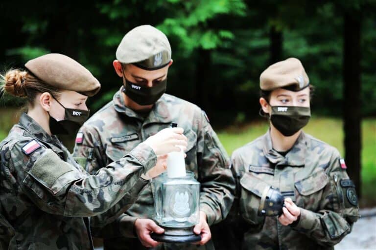 Żołnierze WOT-u wraz z dziećmi nad mogiłą poległych w Bitwie pod Mławą