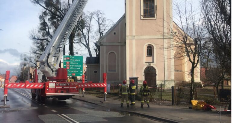 Strażacy zabezpieczają dachówki na kościele. Zamknięta droga krajowa
