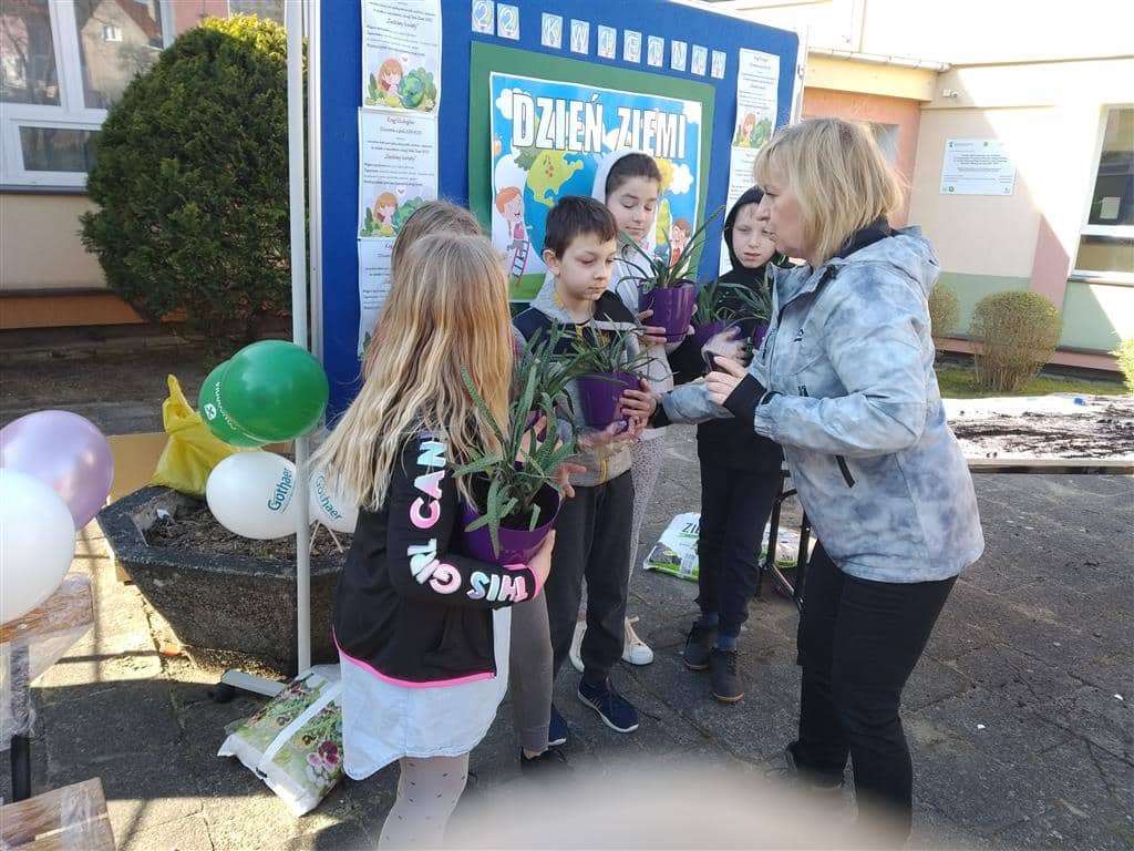 Z okazji Dnia ziemi dzieci wraz z nauczycielami sadziły kwiatki by ożywić przestrzeń w szkole
