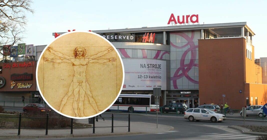 Widok na budynek Aura Centrum w Olsztynie z dużym banerem wystawy Leonarda da Vinci, na pierwszym planie szkic Vitruvian Man.