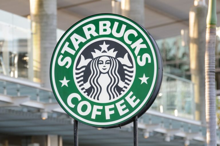 Logo kawiarni Starbucks na tle nowoczesnego budynku w Olsztynie.
