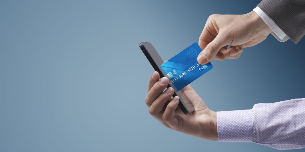 Businessman taking a credit card from a user's smartphone, cybersecurity and phishing concept