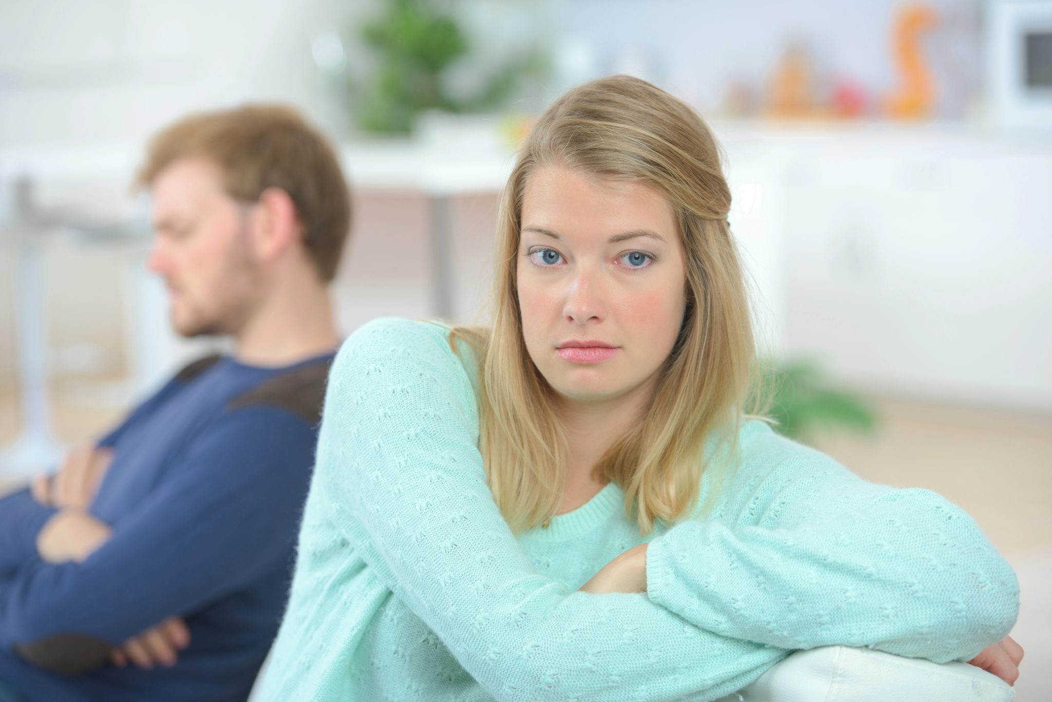 Grumpy couple sat on a sofa