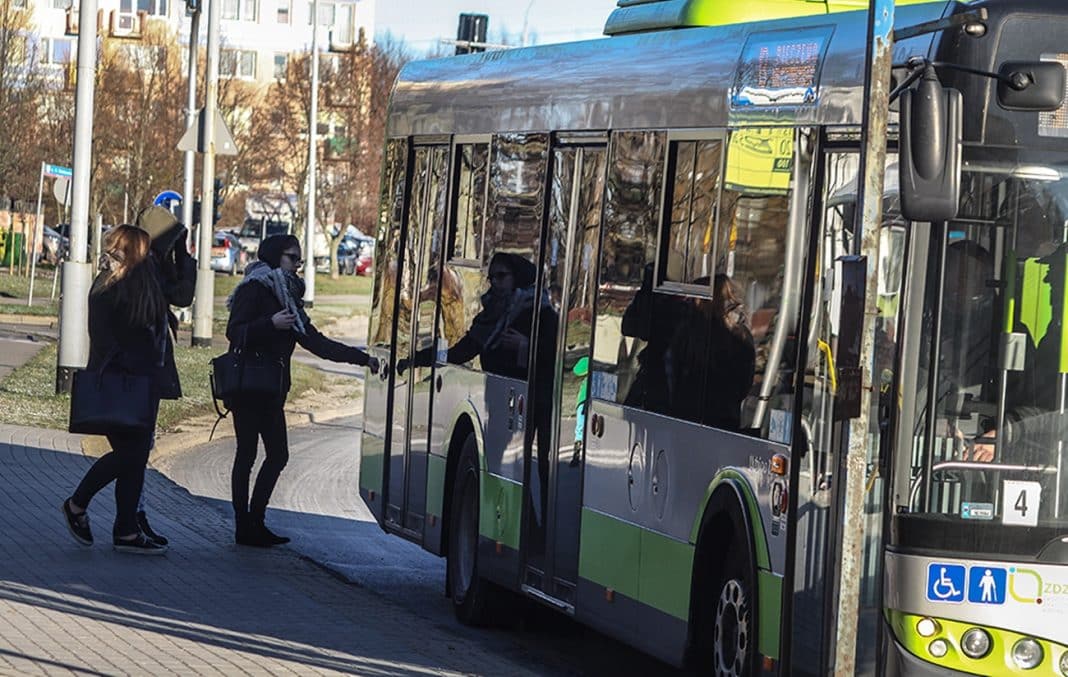 kobieta wsiada do autobusu.