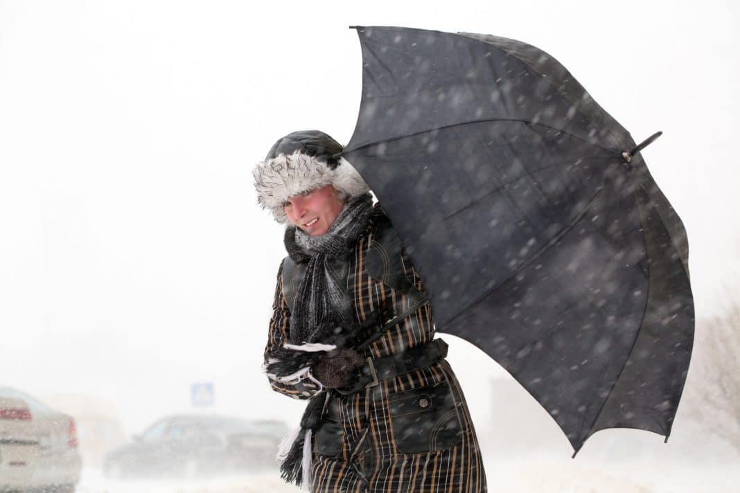 Śnieg z deszczem i kobieta z parasolem