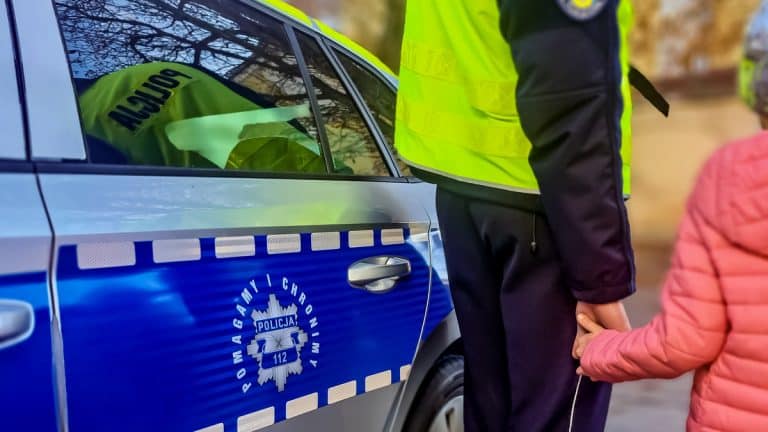 policjant trzyma dziecko za rękę