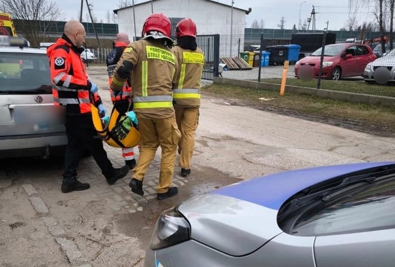 ratownik i strażacy pomagają staruszce