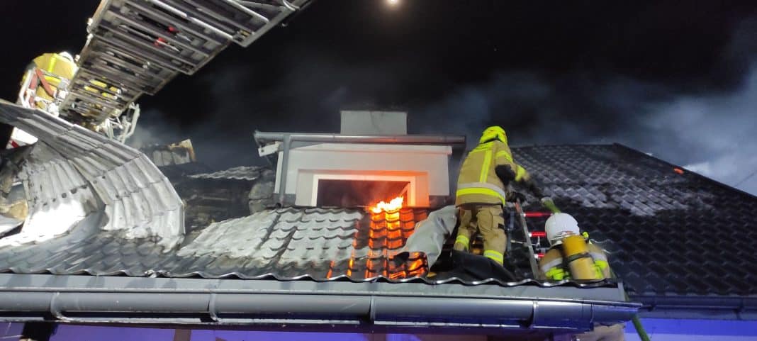 strażacy gaszą pożar dachu domu