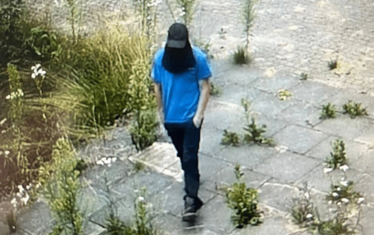 podejrzany idzie włamać się do szkoły w Błudowie owinięty bluzą