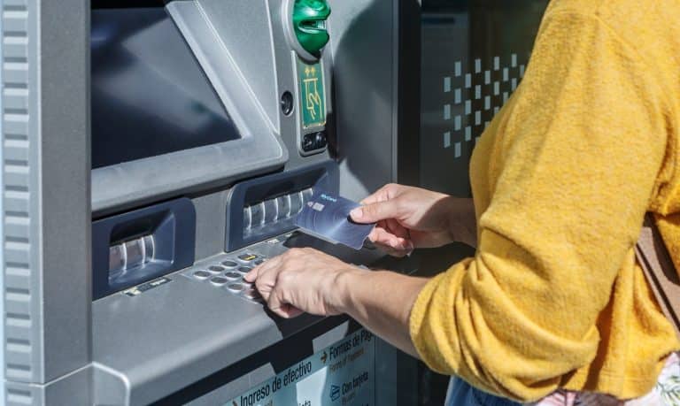 kobieta wypłaca z bankomatu