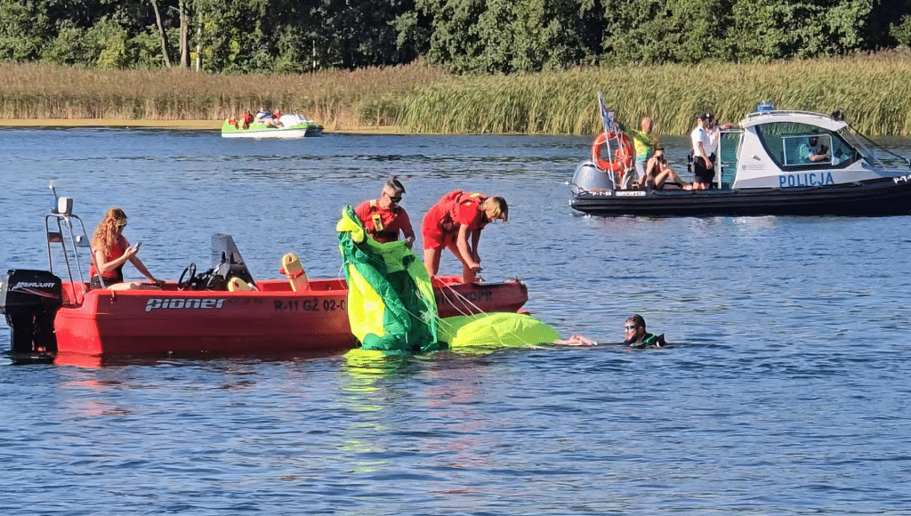 Wszyscy zaskoczeni. Akcja służb ratunkowych na Plaży Miejskiej. - 12 spadochroniarzy wpadło do jeziora Ukiel pełnego turystów. Służby ratunkowe w akcji