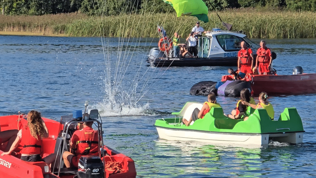 Wszyscy zaskoczeni. Akcja służb ratunkowych na Plaży Miejskiej. - 12 spadochroniarzy wpadło do jeziora Ukiel pełnego turystów. Służby ratunkowe w akcji