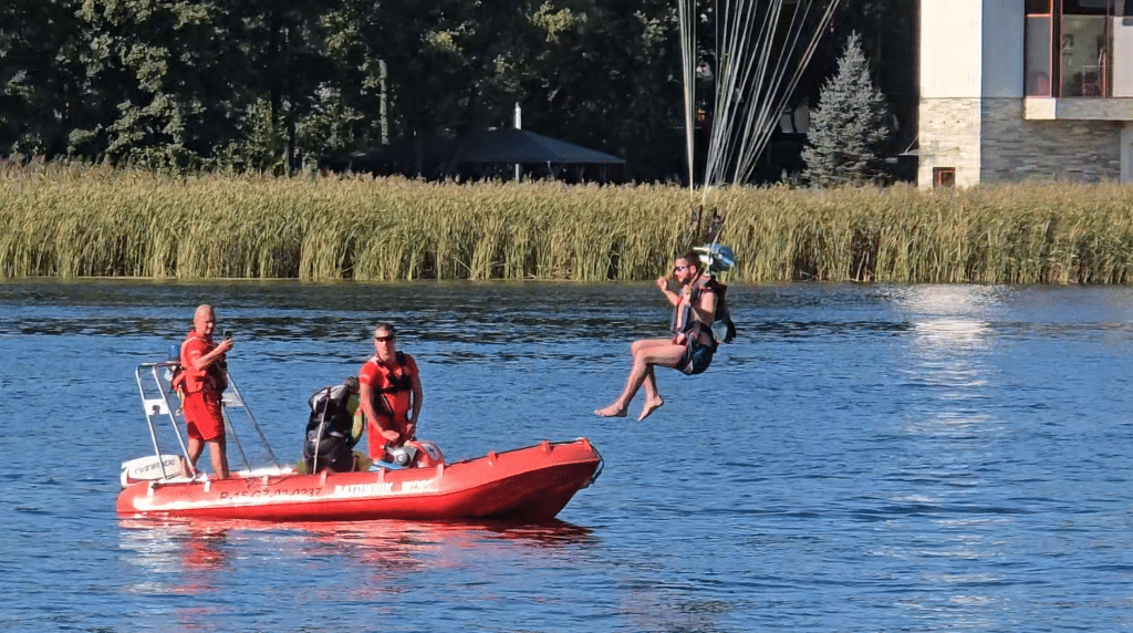 Wszyscy zaskoczeni. Akcja służb ratunkowych na Plaży Miejskiej. - 12 spadochroniarzy wpadło do jeziora Ukiel pełnego turystów. Służby ratunkowe w akcji