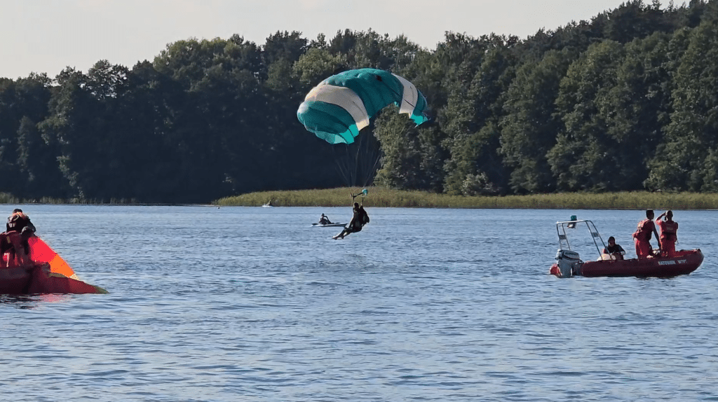Wszyscy zaskoczeni. Akcja służb ratunkowych na Plaży Miejskiej. - 12 spadochroniarzy wpadło do jeziora Ukiel pełnego turystów. Służby ratunkowe w akcji