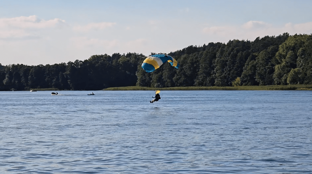 Wszyscy zaskoczeni. Akcja służb ratunkowych na Plaży Miejskiej. - 12 spadochroniarzy wpadło do jeziora Ukiel pełnego turystów. Służby ratunkowe w akcji